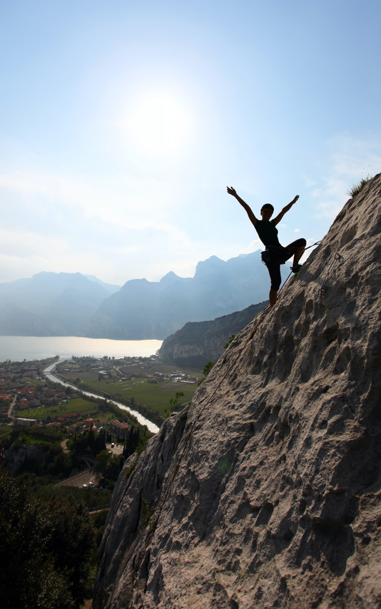 Silhouette of a female rock climber with outstretched arms